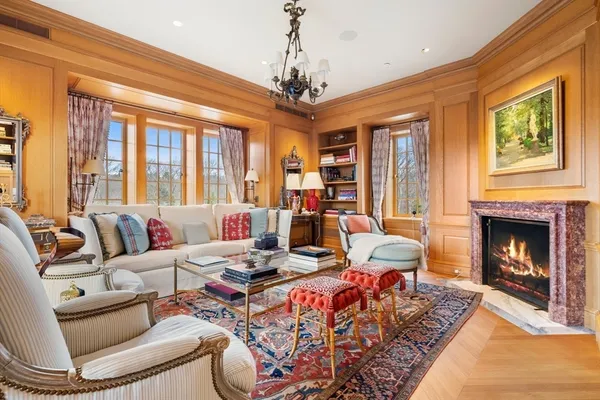 a living room with furniture a chandelier and a fireplace