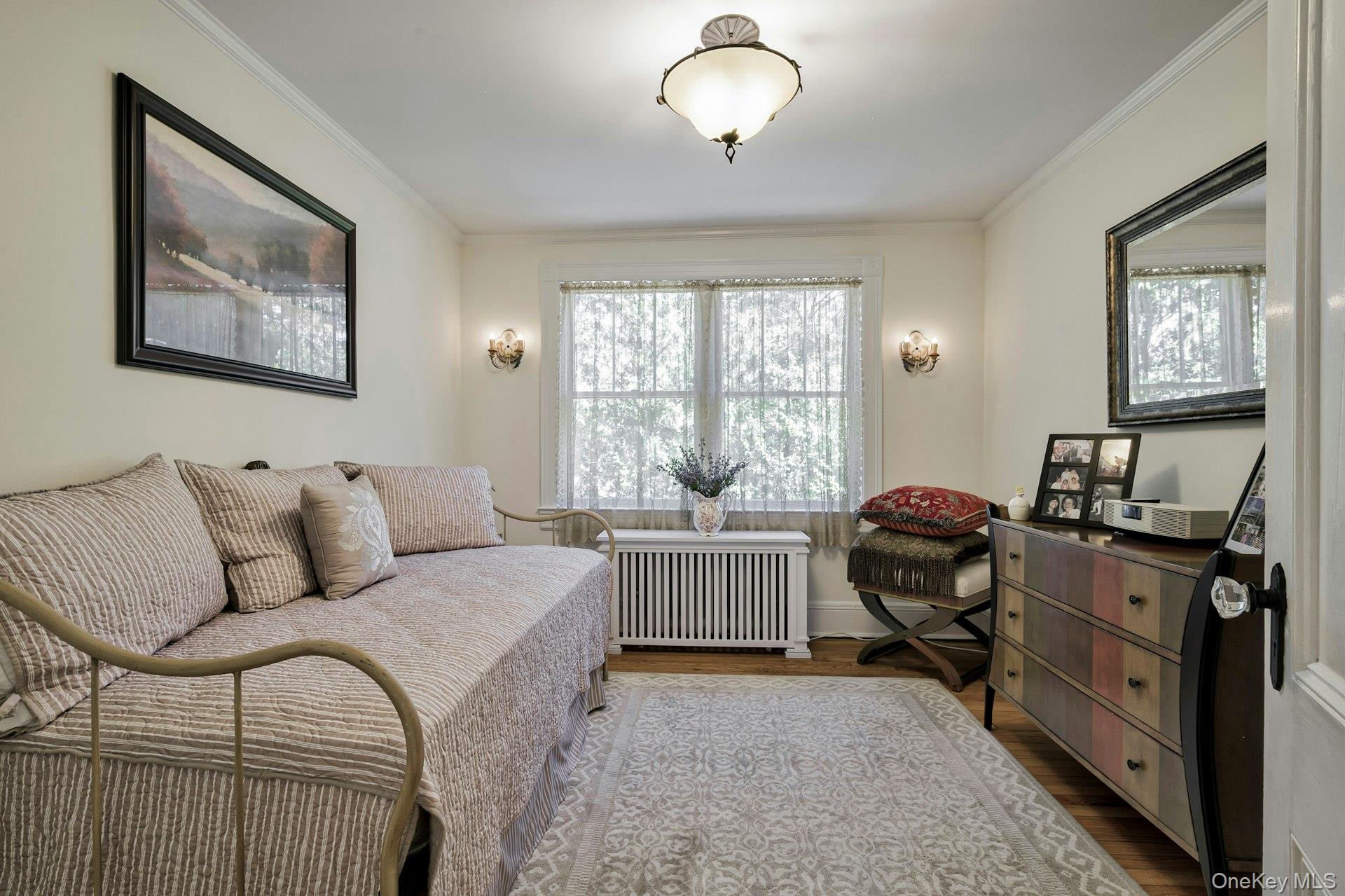126 Cove Road Oyster Bay, NY 11771 - Photo 31 of 42 Bedroom featuring wood finished floors, multiple windows, radiator heating unit, and ornamental molding