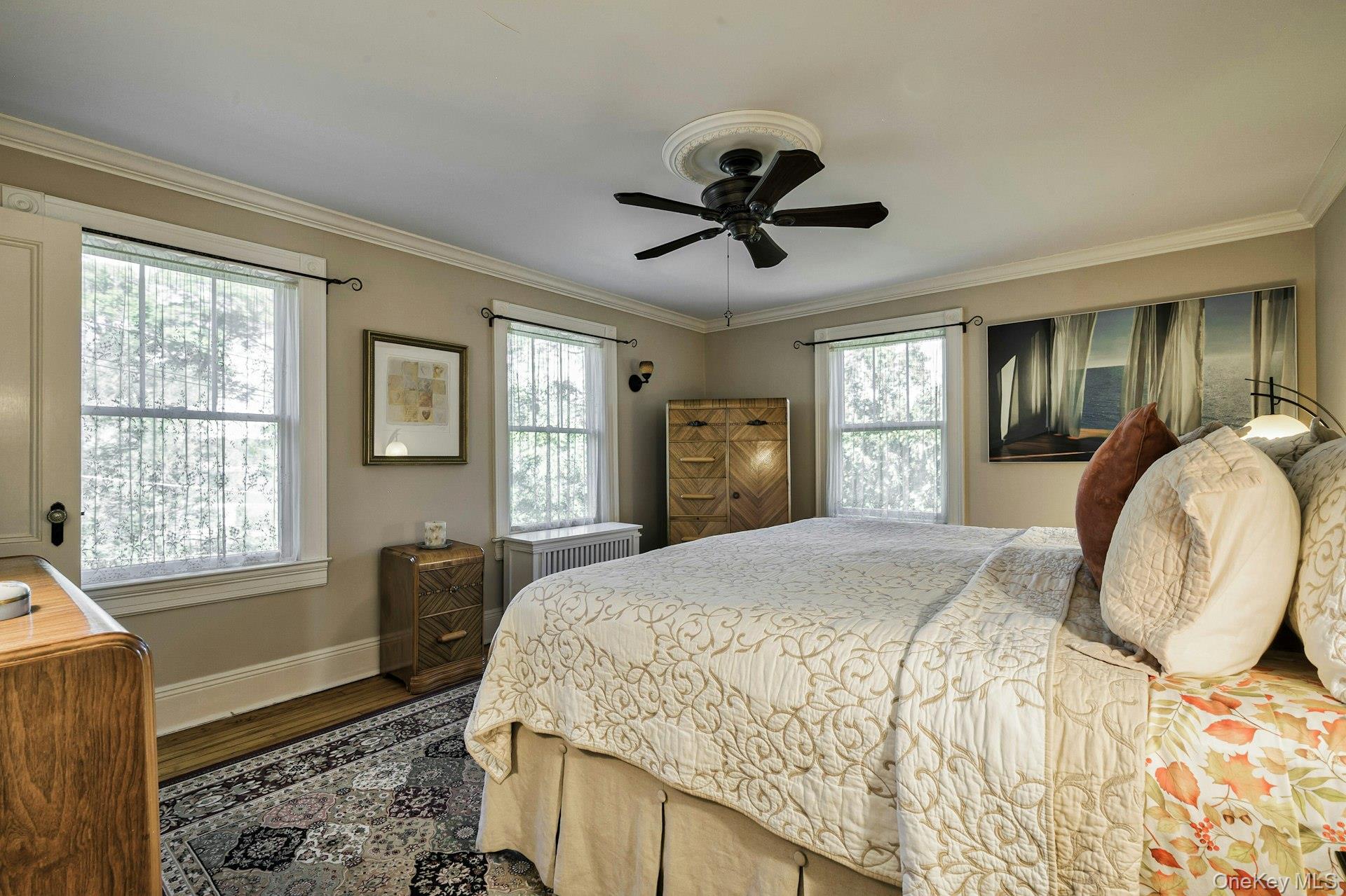 126 Cove Road Oyster Bay, NY 11771 - Photo 34 of 42 Bedroom featuring ornamental molding, dark wood-type flooring, and a ceiling fan