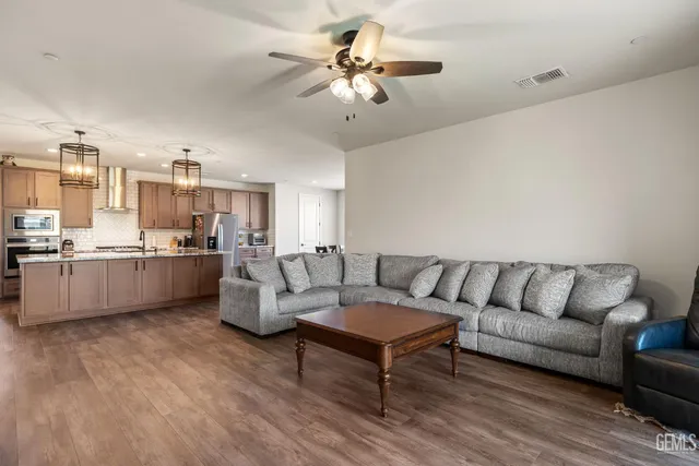 a living room with furniture kitchen view and a chandelier