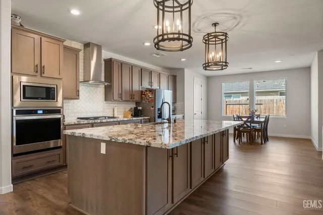 a kitchen with stainless steel appliances granite countertop a stove and cabinets