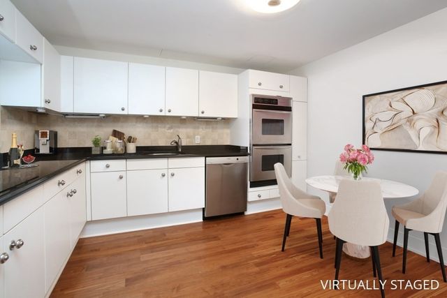 a kitchen with granite countertop a sink cabinets stainless steel appliances and dining table