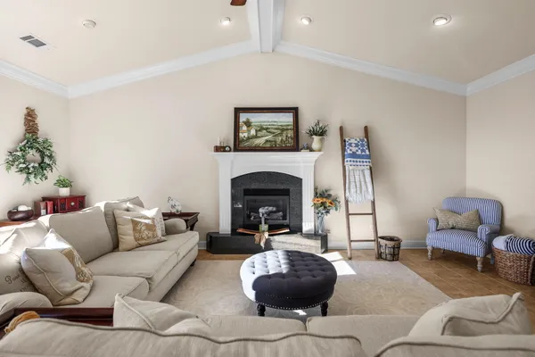 a living room with furniture kitchen view and a chandelier