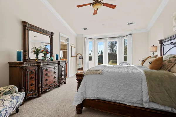 a bed sitting in a bedroom and chair