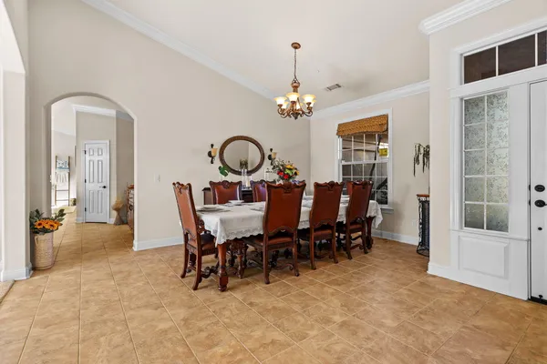 a kitchen with stainless steel appliances a dining table chairs refrigerator and sink