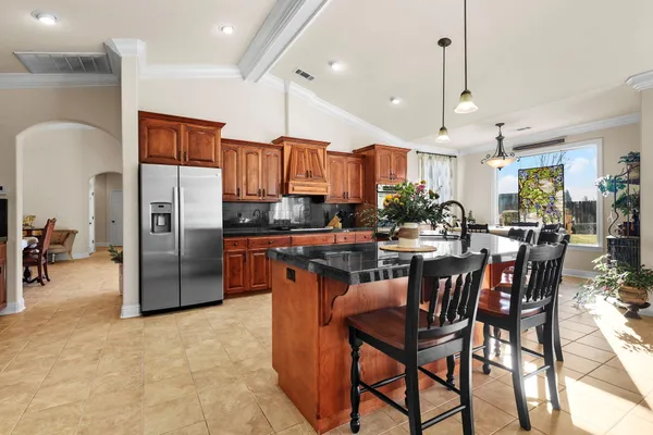 a kitchen with stainless steel appliances granite countertop a refrigerator a sink and a stove