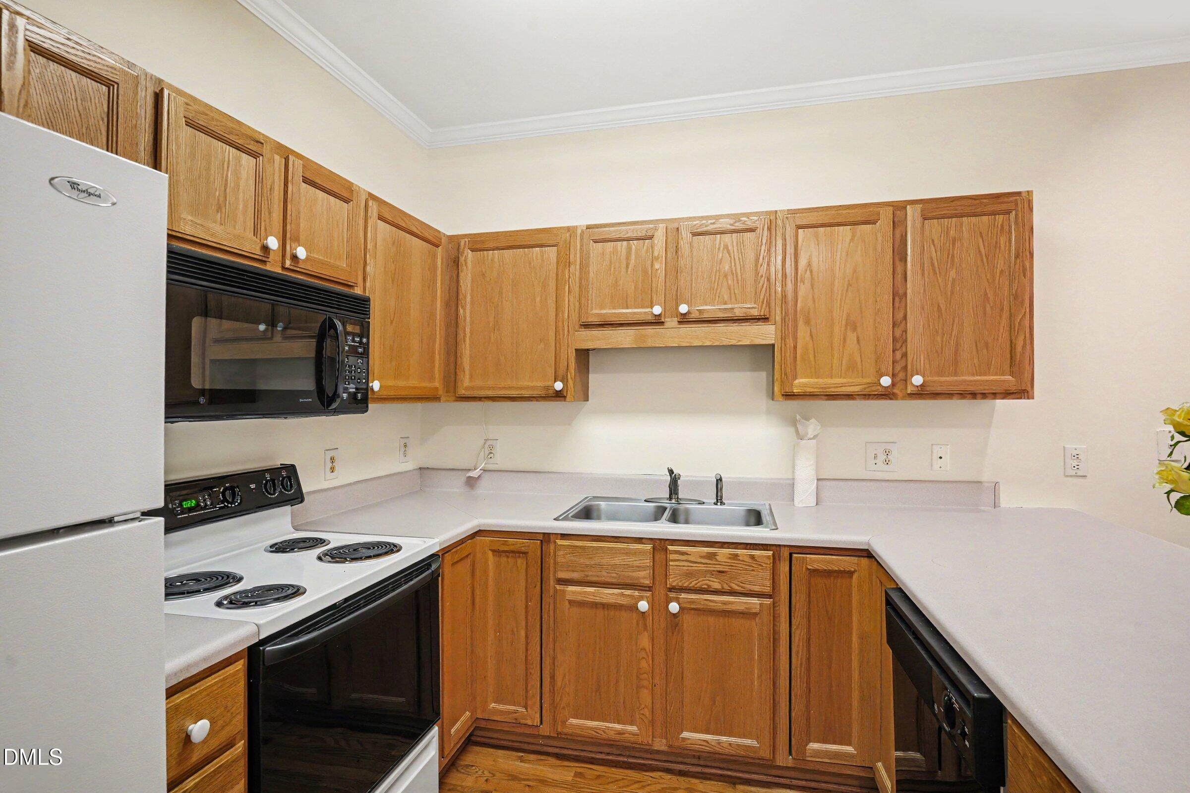 2651 Mellowfield Drive, Unit 203 Raleigh, NC 27604 - Photo 5 of 32 a kitchen with stainless steel appliances granite countertop a sink stove and microwave