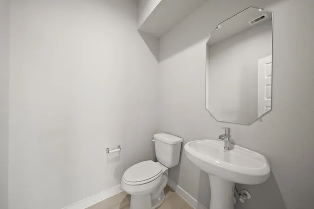 a bathroom with a sink toilet and a mirror