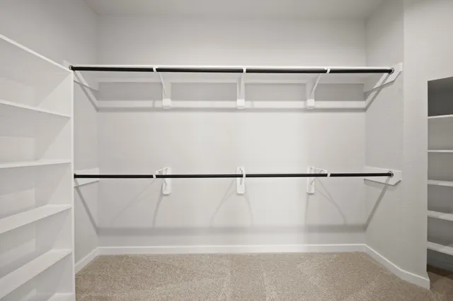 a view of walk in closet with empty racks