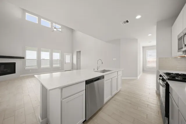 a kitchen with a sink stove and cabinets