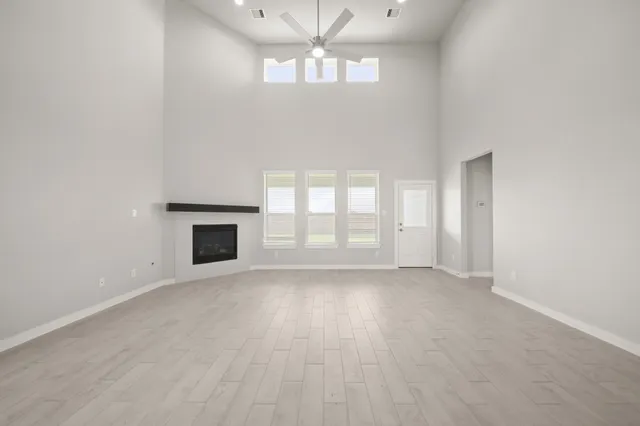 a view of an empty room with a window and fireplace