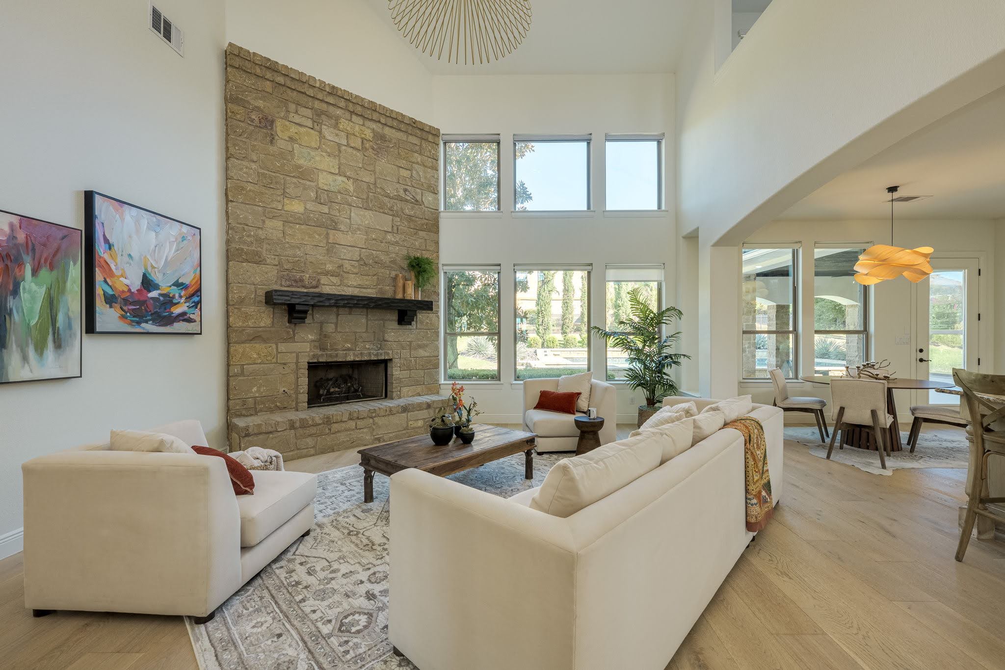 11612 Shoreview Overlook Austin, TX 78732 - Photo 8 of 40 A floor-to-ceiling stone fireplace serves as the centerpiece of this light-filled room with wood flooring.