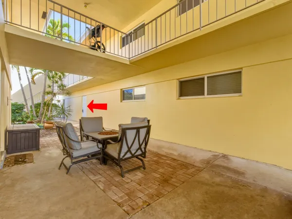 a view of a chairs and table in the back yard of the house