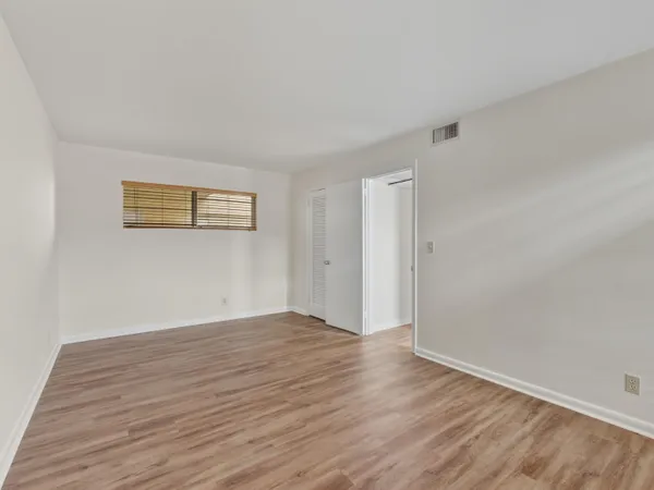a view of an empty room with wooden floor