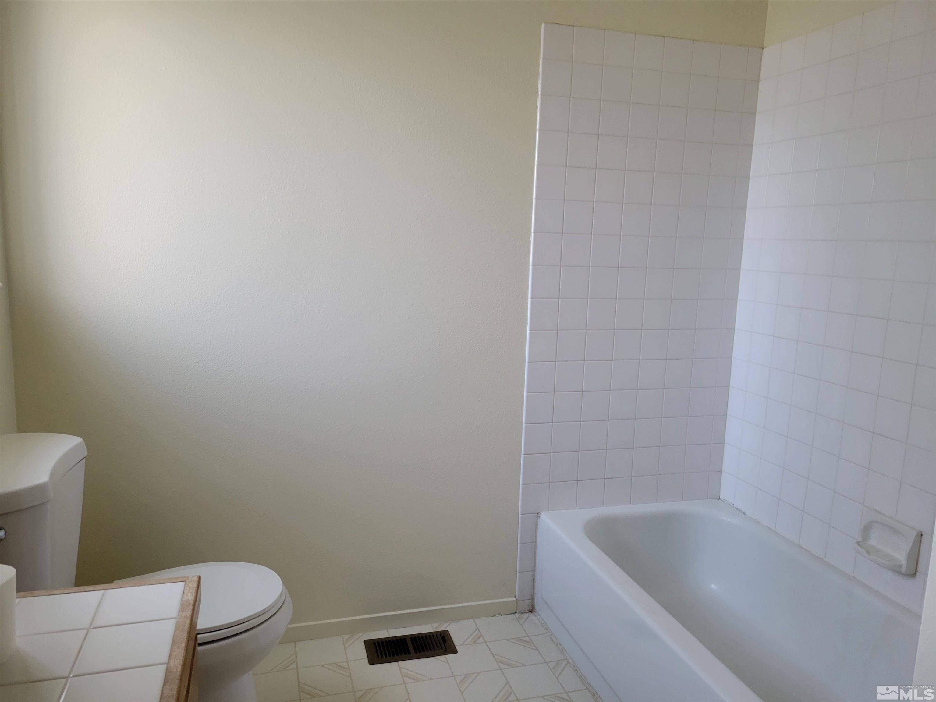 10405 Bounder Lane Reno, NV 89508 - Photo 14 of 16 a white bath tub sitting next to a toilet