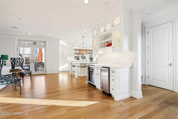 a kitchen with stainless steel appliances kitchen island granite countertop a stove a sink a dining table and chairs with wooden floor