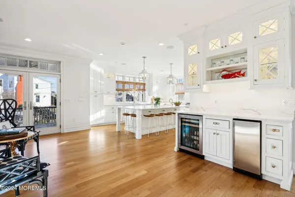 a kitchen with stainless steel appliances kitchen island granite countertop a table chairs and a refrigerator