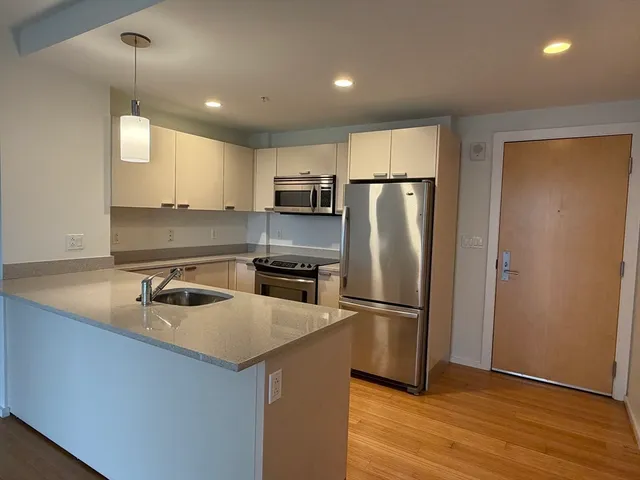 a kitchen with kitchen island a counter top space cabinets and stainless steel appliances
