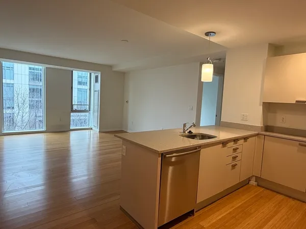 a view of a kitchen with sink and wooden floor