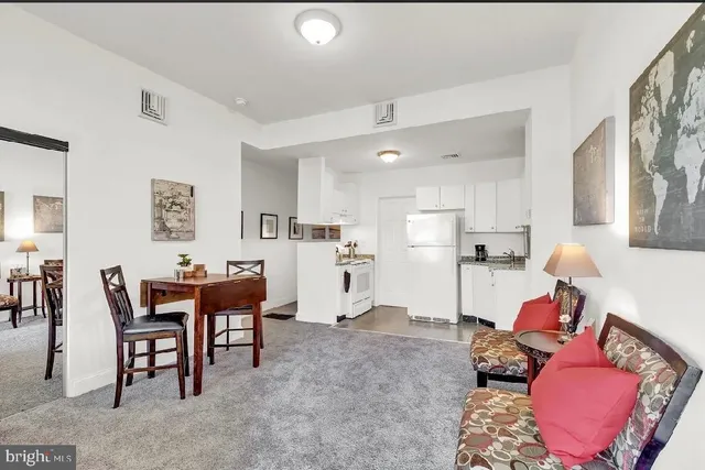 a living room with furniture and kitchen view