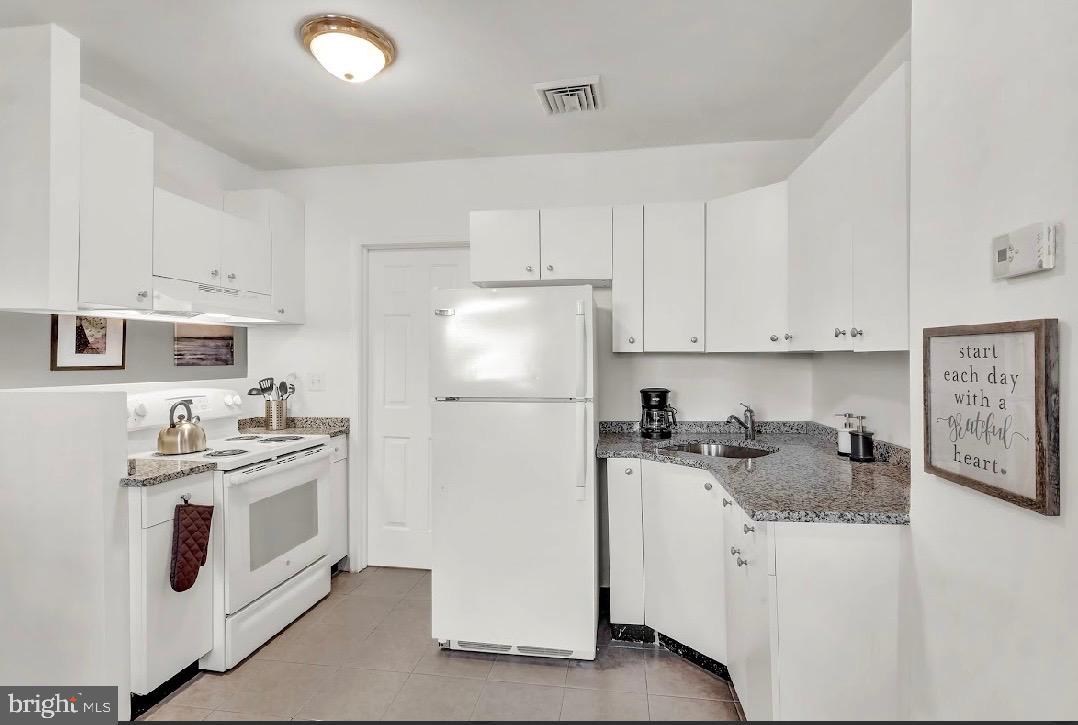 468 East Walnut Lane, Unit 1 Philadelphia, PA 19144 - Photo 7 of 17 a kitchen with stainless steel appliances granite countertop a stove a refrigerator a sink a stove and white cabinets