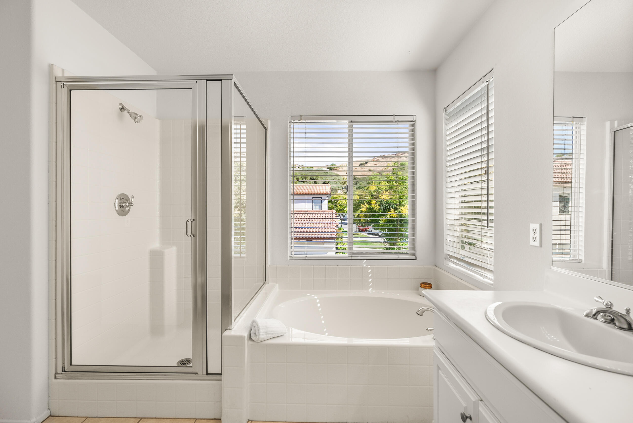 25803 Hammet Circle Stevenson Ranch, CA 91381 - Photo 23 of 32 a bathroom with a sink a bathtub and next to a window