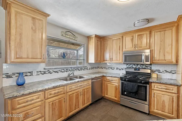 a kitchen with stainless steel appliances granite countertop a stove sink and cabinets