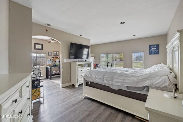 a spacious bedroom with a bed and a flat screen tv