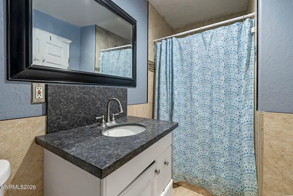 a bathroom with a granite countertop sink and a mirror