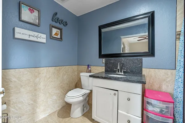 a bathroom with a toilet a sink and mirror