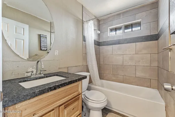 a bathroom with a granite countertop sink mirror toilet and bathtub