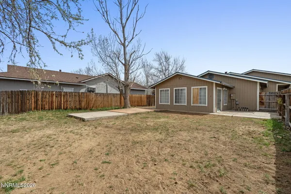 a front view of a house with a yard and wooden fence