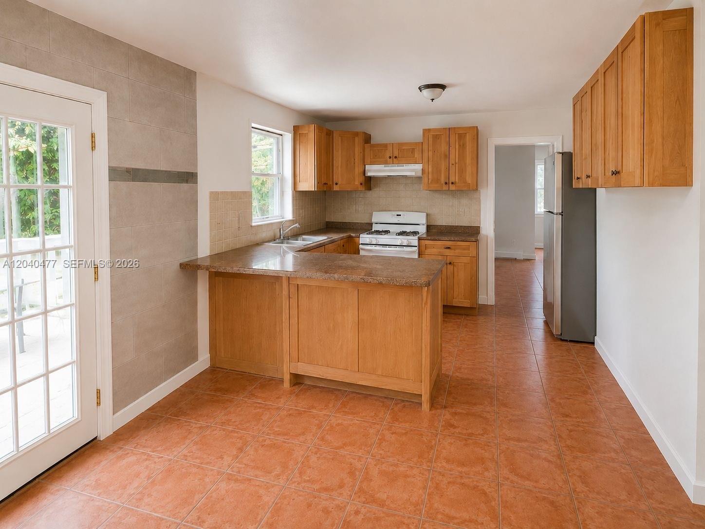 9110 Southwest 44th Street Miami, FL 33165 - Photo 16 of 18 a kitchen with stainless steel appliances a stove top oven a refrigerator a sink a counter space and cabinets