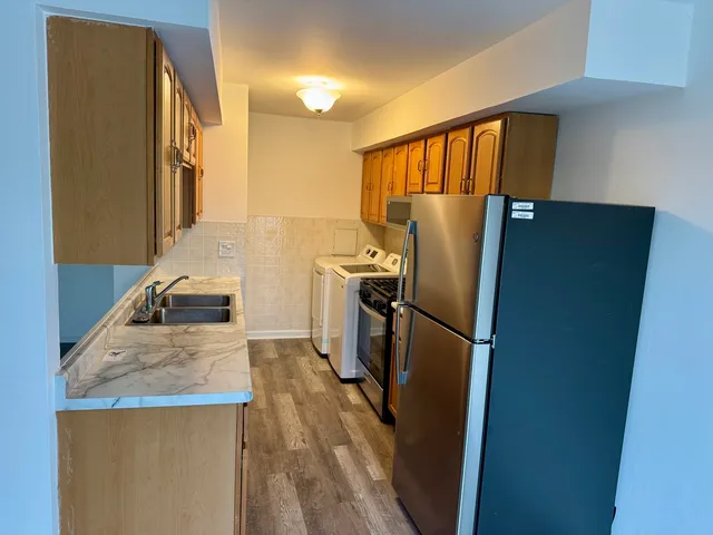 a kitchen with granite countertop a refrigerator and a sink