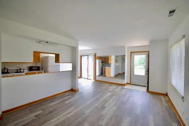 a view of a kitchen with wooden floor and a window