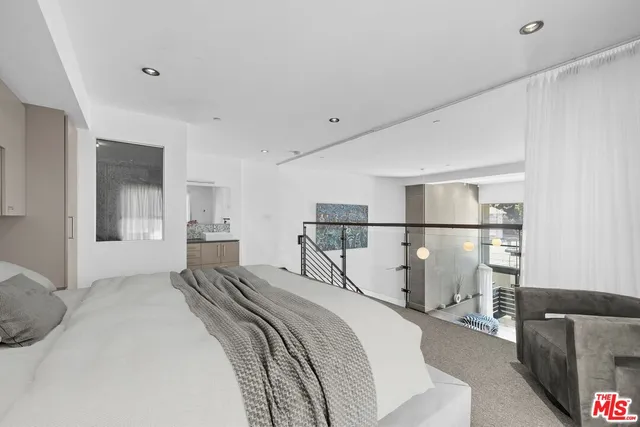 a bed room with a bed and a view of kitchen