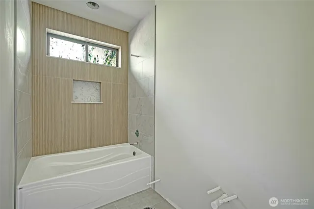 a bathroom with a bathtub a window and a toilet