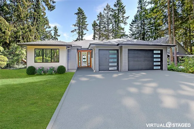 a front view of a house with a garden and trees