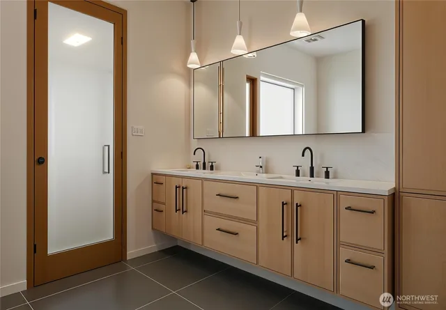 a spacious bathroom with a double vanity sink a mirror and a
