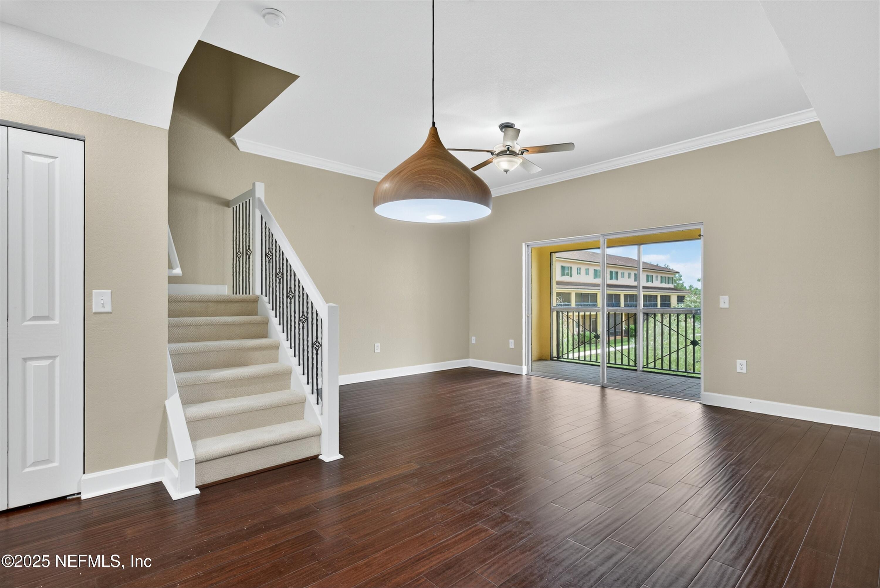 9745 Touchton Road, Unit 1625 Jacksonville, FL 32246 - Photo 13 of 69 a view of an empty room with wooden floor and a chandelier