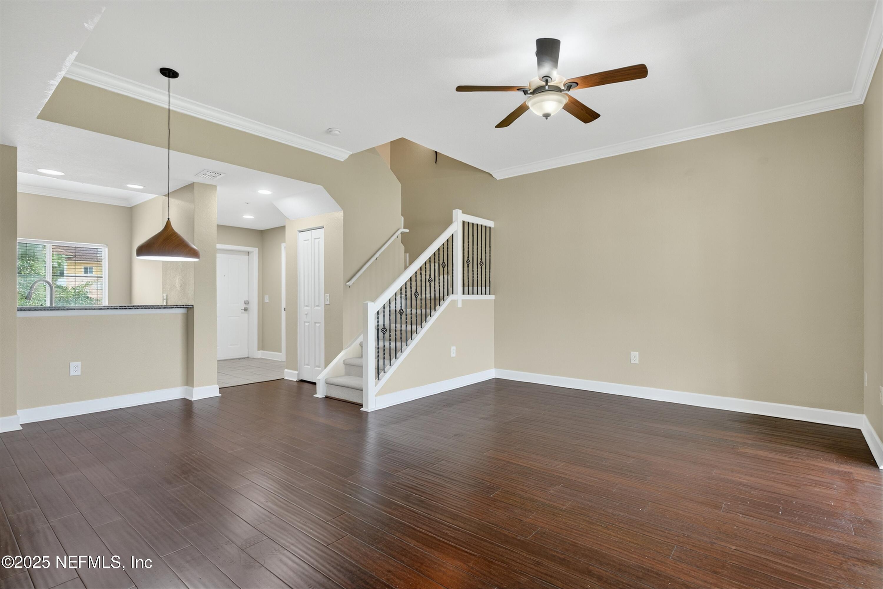9745 Touchton Road, Unit 1625 Jacksonville, FL 32246 - Photo 16 of 69 a view of an empty room with wooden floor and a ceiling fan