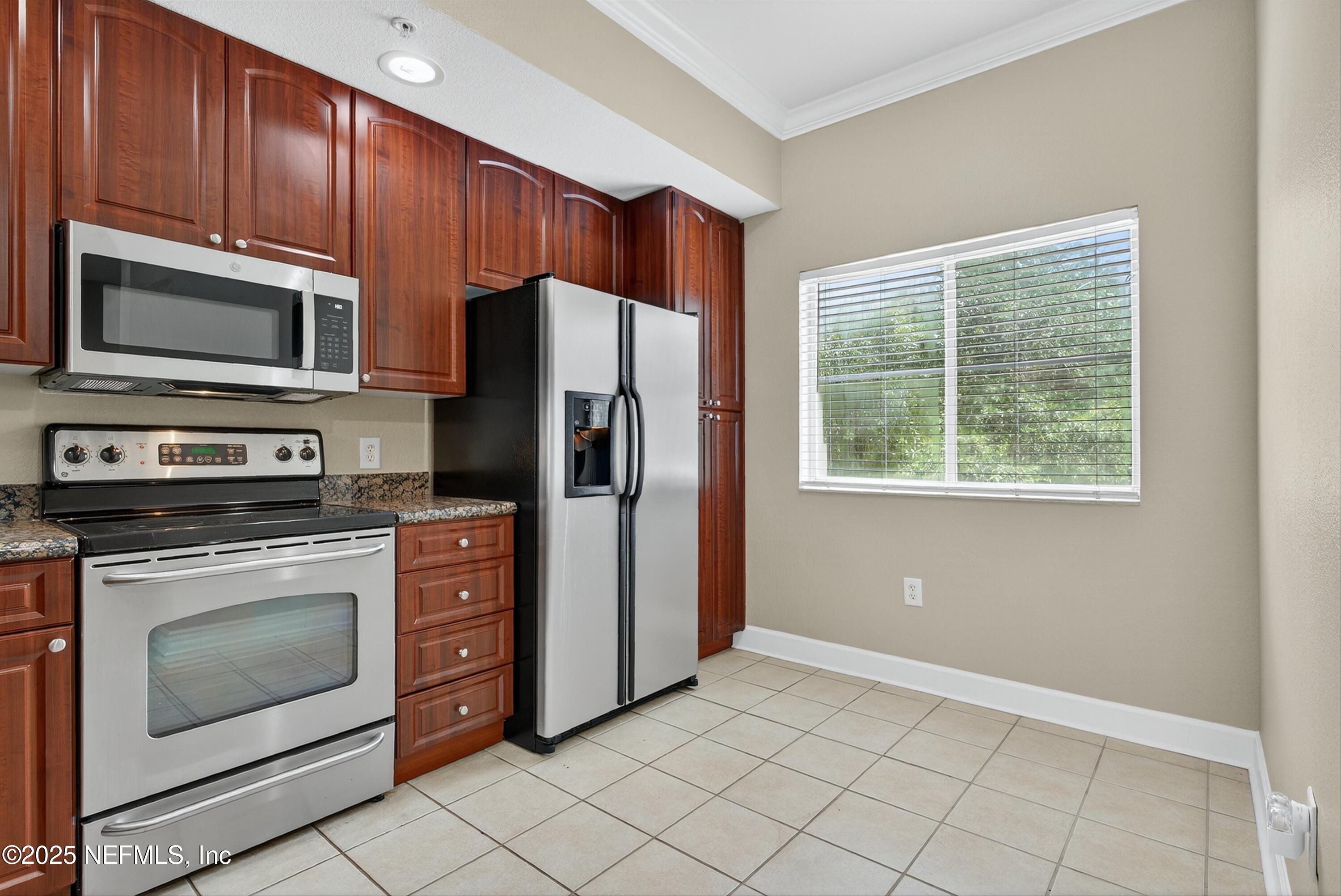 9745 Touchton Road, Unit 1625 Jacksonville, FL 32246 - Photo 29 of 69 a kitchen with granite countertop wooden cabinets stainless steel appliances and a window