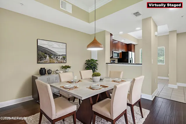 a view of an empty room with wooden floor and a chandelier