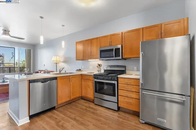 a kitchen with stainless steel appliances a refrigerator stove microwave and sink
