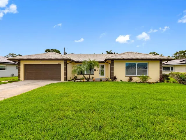 a front view of a house with a garden and yard