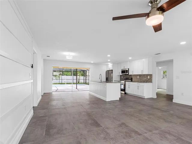 a kitchen with stainless steel appliances granite countertop a stove a microwave and white cabinets