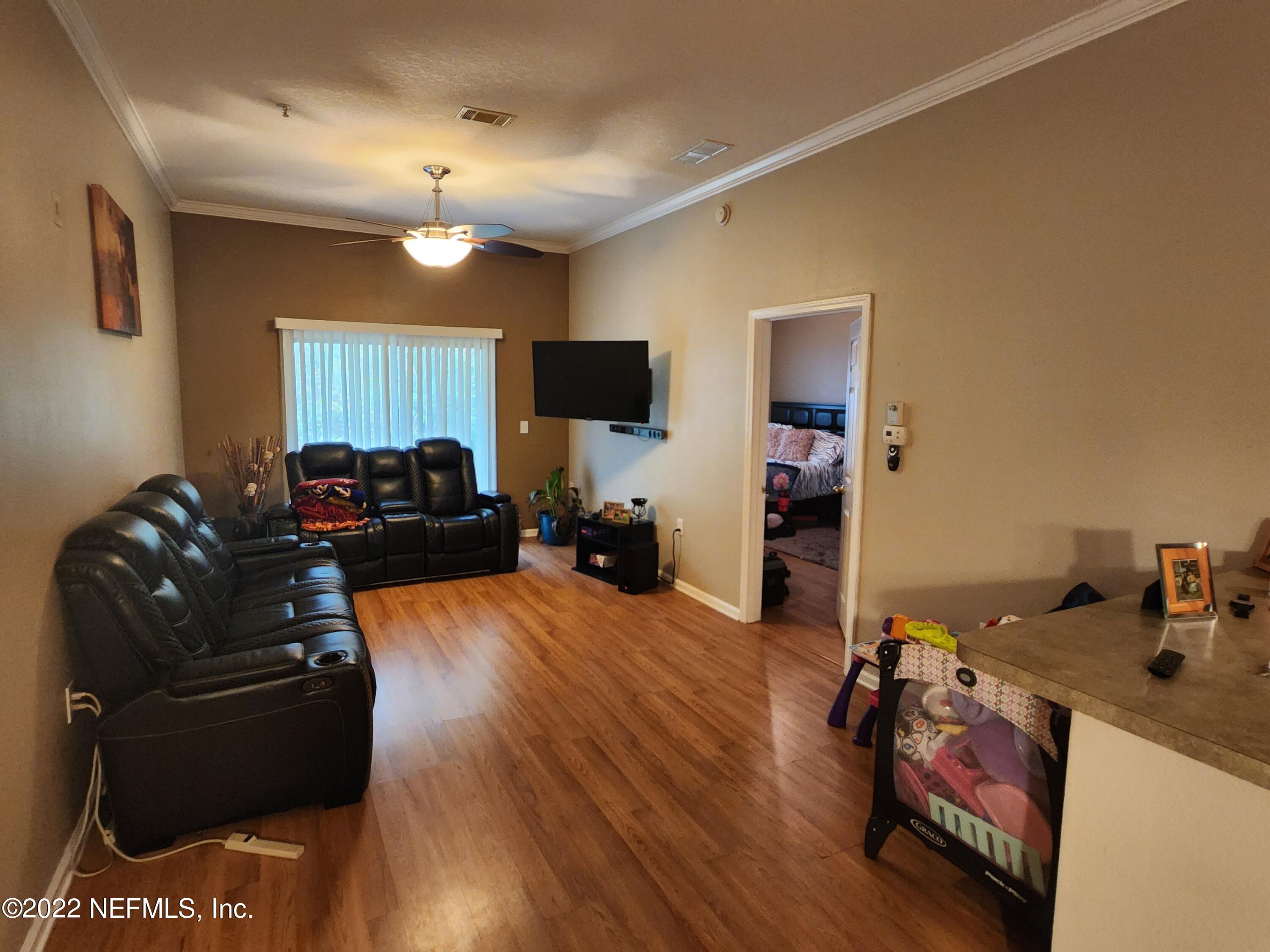 7920 Merrill Road, Unit 1704 Jacksonville, FL 32277 - Photo 3 of 11 a living room with furniture and a flat screen tv