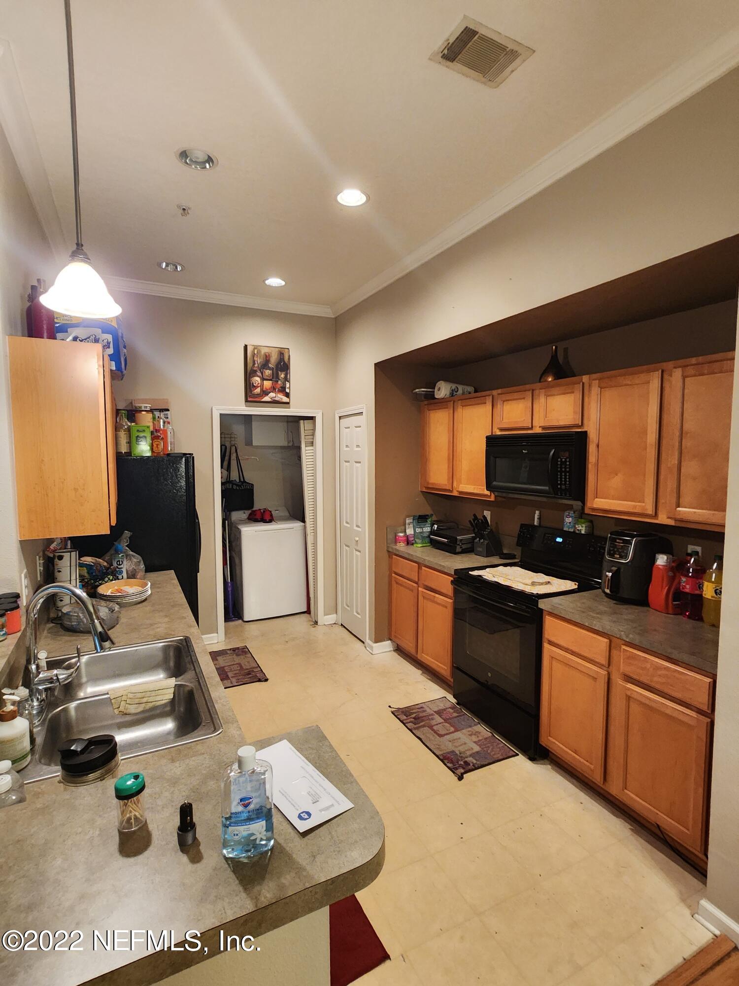 7920 Merrill Road, Unit 1704 Jacksonville, FL 32277 - Photo 4 of 11 a kitchen with stainless steel appliances kitchen island granite countertop a sink dishwasher stove and refrigerator with wooden floor