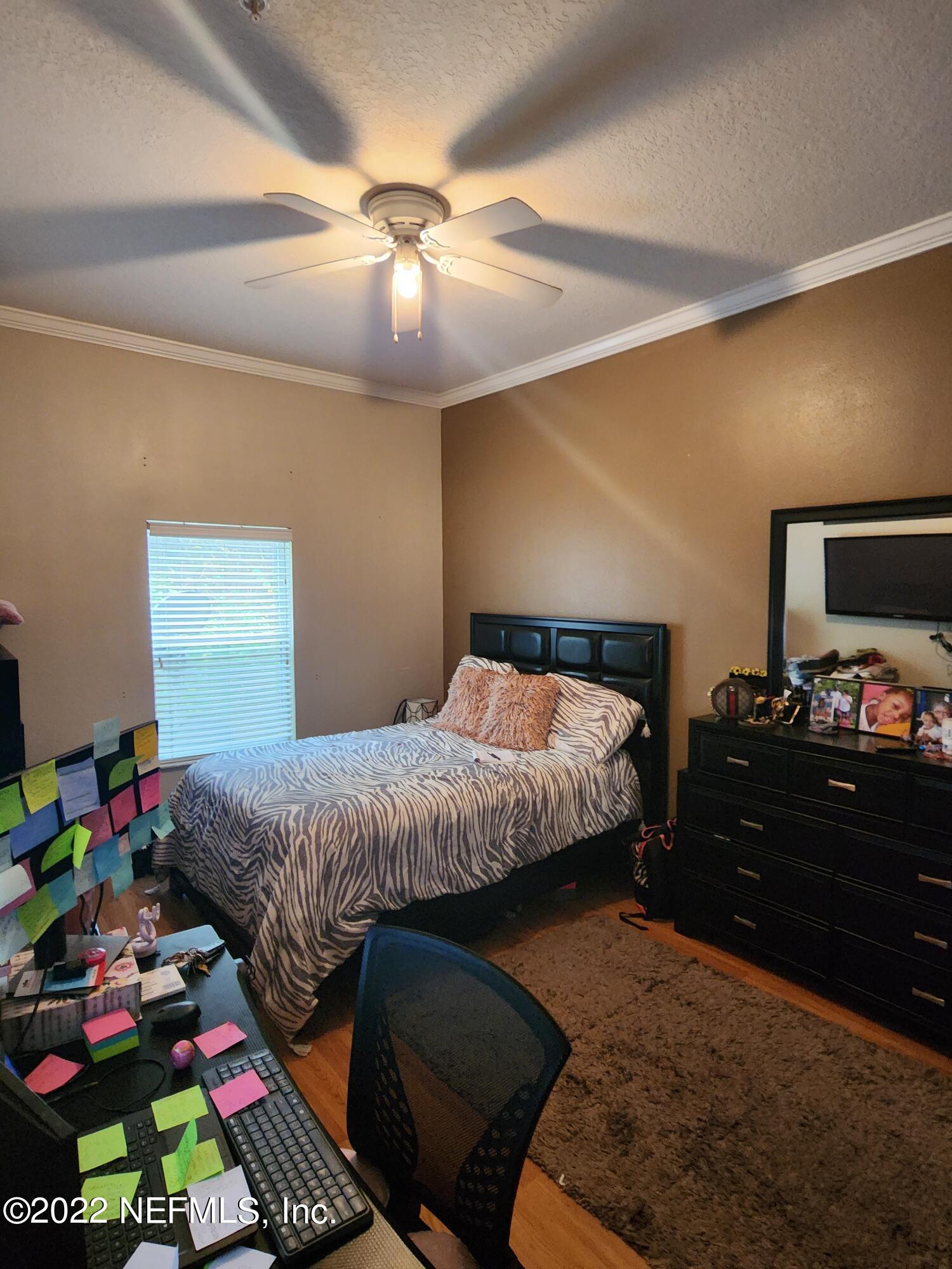 7920 Merrill Road, Unit 1704 Jacksonville, FL 32277 - Photo 5 of 11 a bedroom with a bed and a chandelier
