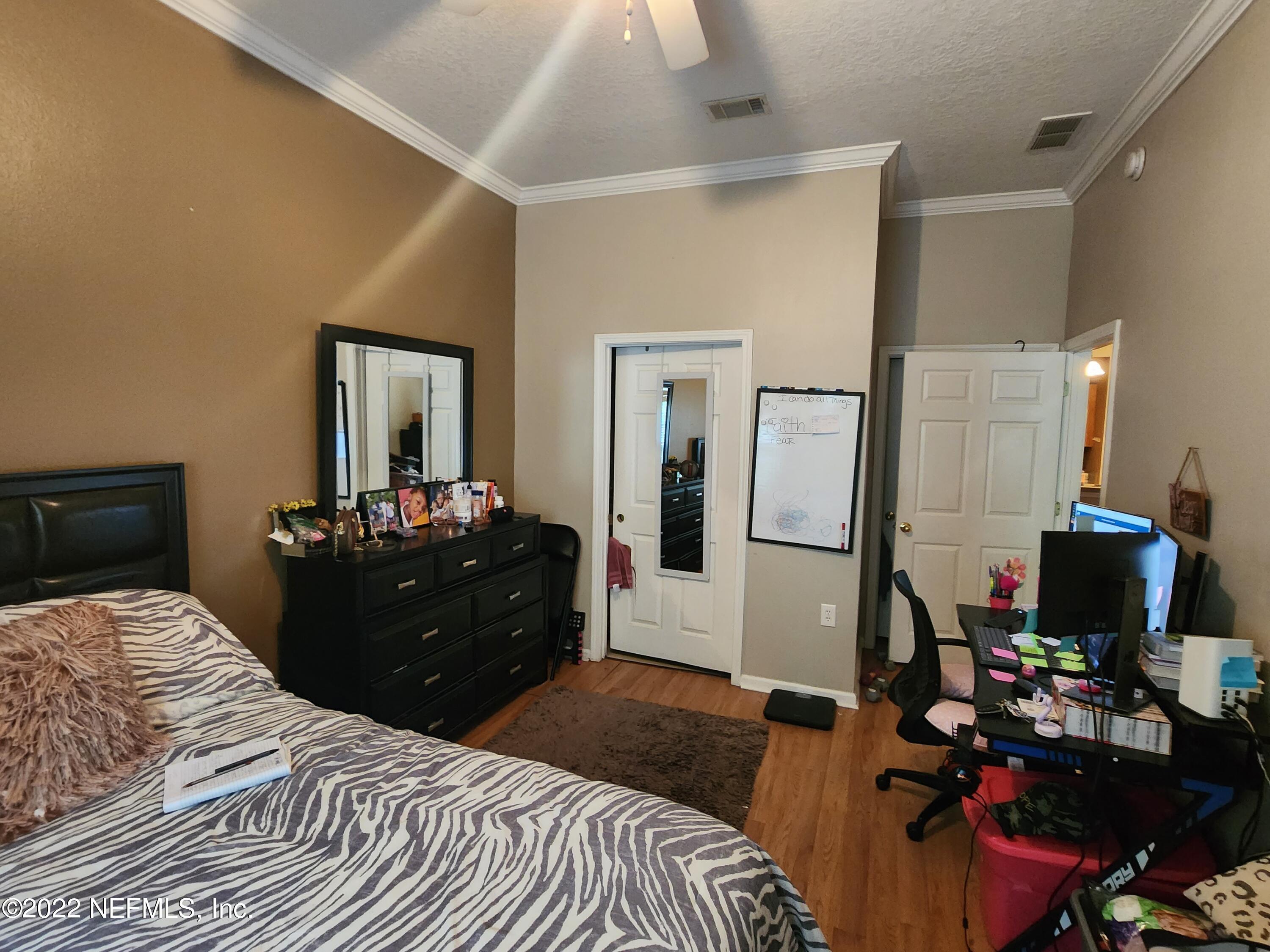 7920 Merrill Road, Unit 1704 Jacksonville, FL 32277 - Photo 6 of 11 a bedroom with a bed and a mirror